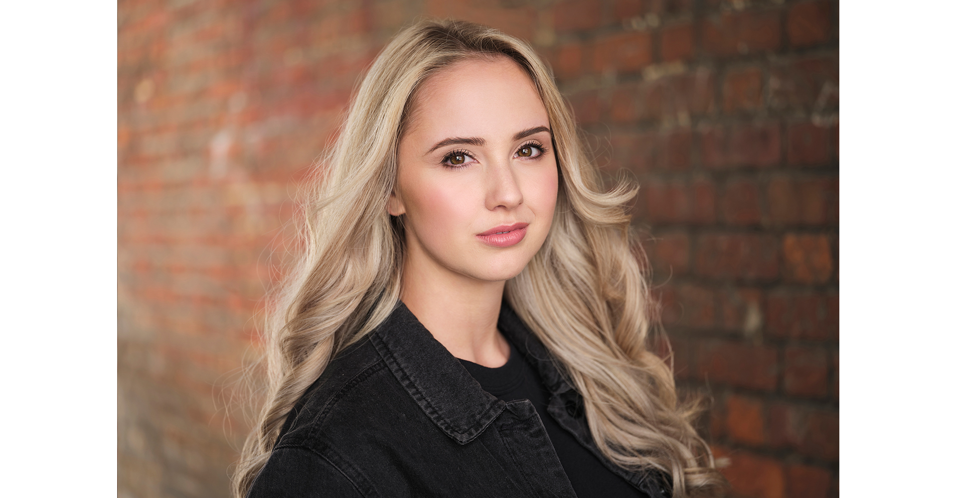 Blonde actress headshots portrait front of a brick wall in natural light